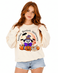 Cream unisex crewneck sweatshirt with cute illustrated witch reading a book design surrounded by pumpkins and autumn leaves, perfect for Halloween-loving readers