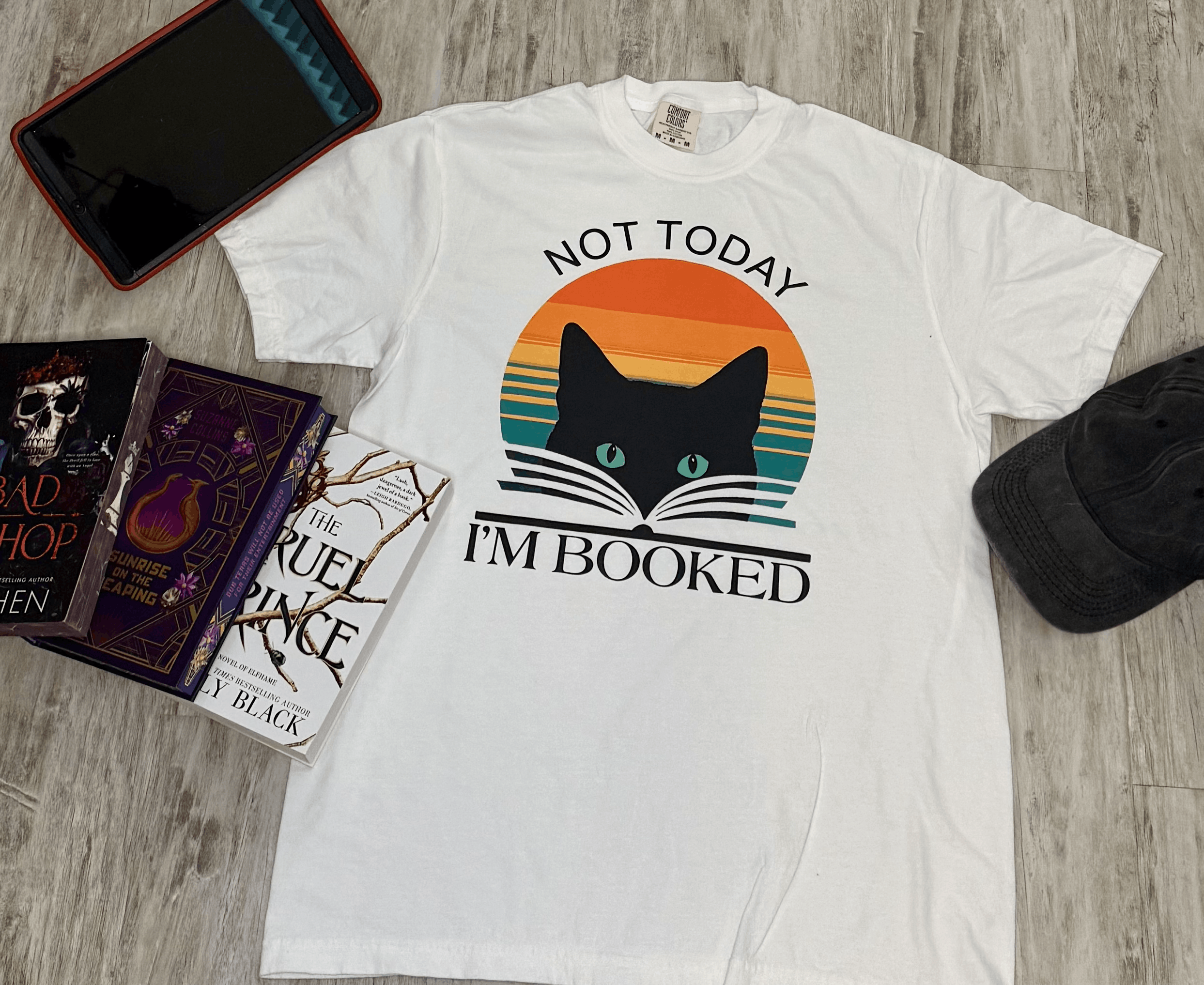 White t-shirt with a cute cat graphic and 'Not Today, I'm Booked' text on it. Your go-to shirt for going out and about.