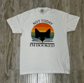 White t-shirt with a cat and book graphic and text 'Not Today, I'm Booked' on a wooden surface.