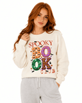 Cream unisex crewneck sweatshirt with colorful "Spooky Book Club" design featuring pumpkins, bats, and patterned letters for Halloween-loving readers