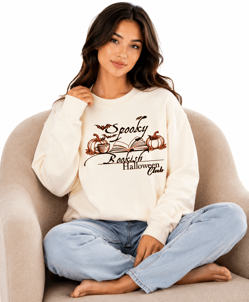 Cream unisex crewneck sweatshirt with elegant hand-drawn spooky bookish Halloween club design featuring open book, pumpkins, coffee cup, bats and leaves with calligraphy text