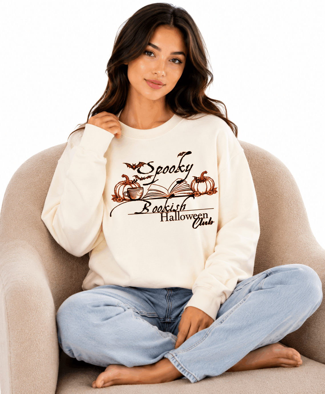 Cream unisex crewneck sweatshirt with elegant hand-drawn spooky bookish Halloween club design featuring open book, pumpkins, coffee cup, bats and leaves with calligraphy text