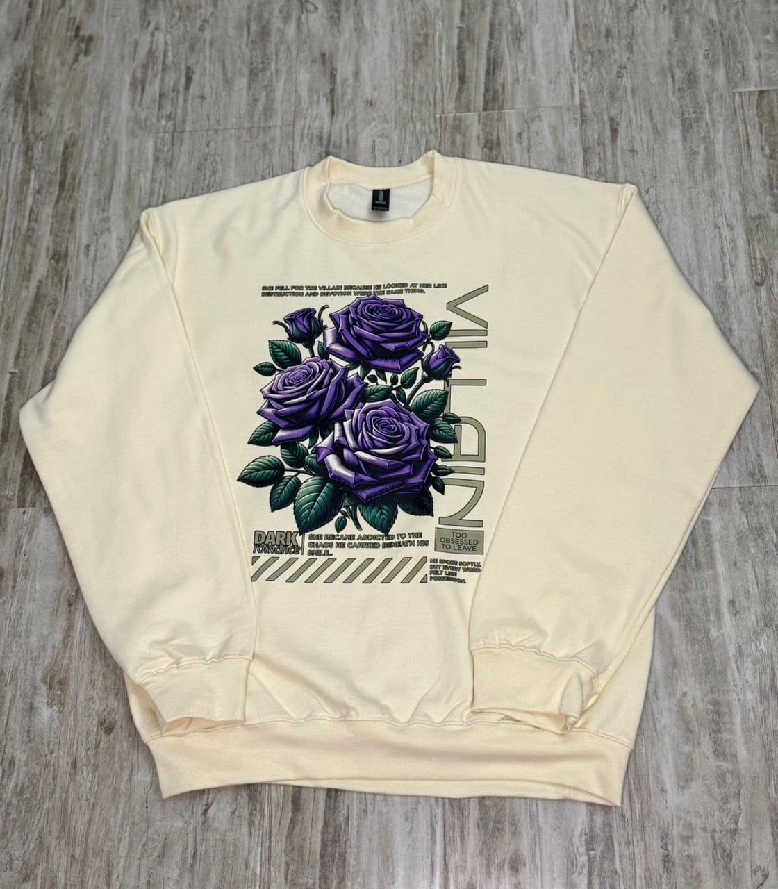 Cream unisex sweatshirt with purple roses graphic and "VILLAIN" text design for dark romance readers


